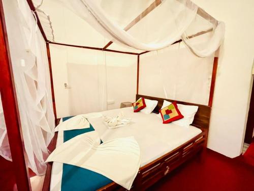 a small bed in a room with a mirror at Golden Breeze Arugambay in Arugam Bay
