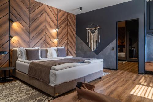 a bedroom with a large bed with a wooden wall at Didukh Eco Hotel&Spa in Bukovel