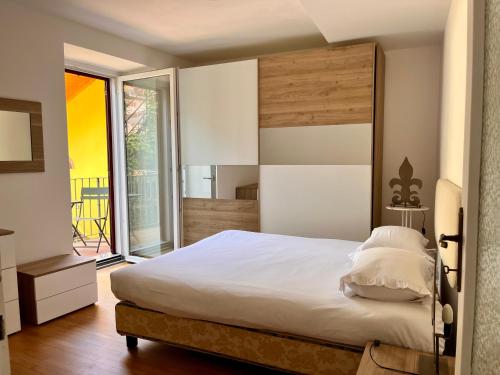 a bedroom with a large bed and a large window at Vicolo Carate in Gravedona