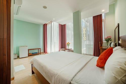 a bedroom with a large bed and a large window at Art Deluxe Hotel in Nha Trang