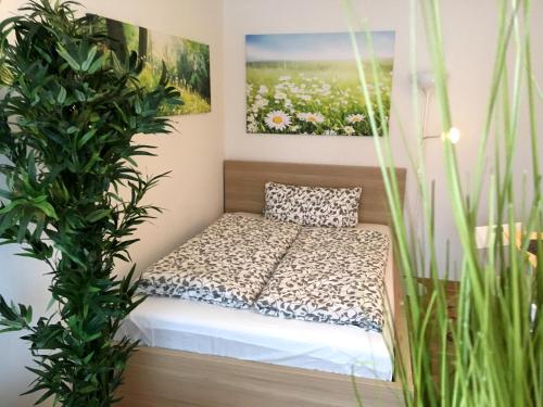 a small bed in a room with plants at Apartment Flowerside in Regensburg