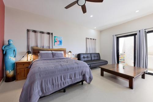 a bedroom with a bed and a table and a couch at Casa Girasol Ocean Views Steps to Beach in Buenavista
