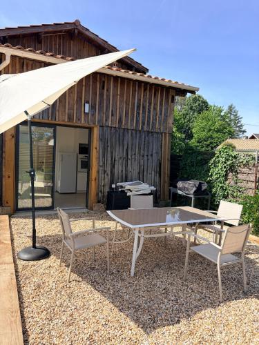 a table and chairs in front of a building at Grange 4 couchages in Mios