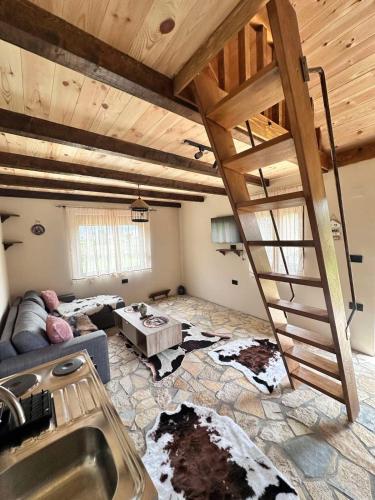 a living room with a wooden staircase in a house at Falcon Cottage,Montenegro in Korita