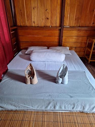 a bed with a pair of shoes sitting on it at Nuttonton Homes in Papas