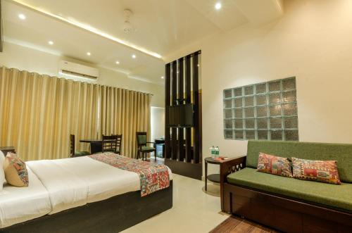 a bedroom with a bed and a couch at Jullundur Hotel & Restaurant in Chandīgarh