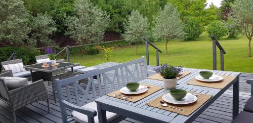 a patio with a table and chairs on a deck at Błękitny Domek in Wydminy