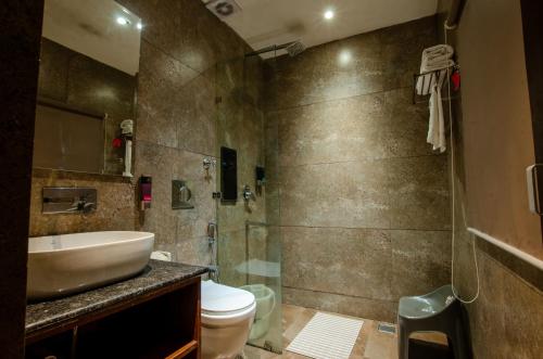 a bathroom with a sink and a toilet and a shower at Jullundur Hotel & Restaurant in Chandīgarh