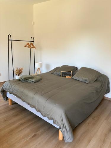 a bedroom with a large bed with a laptop on it at Le Cabanon de Pépé in Mane