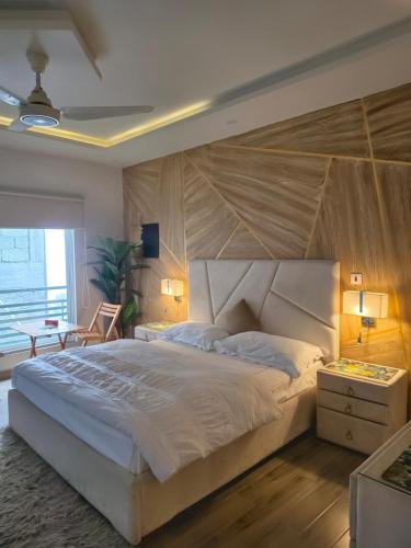 a bedroom with a large bed with a large wooden headboard at The Crib, Murree Hills in Lower Topa