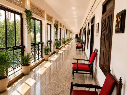 a corridor of a building with chairs and plants at Central Hotel in Lucknow