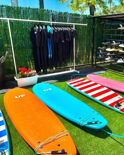a group of surfboards on the grass next to a fence at Hostal de Berria in Santoña