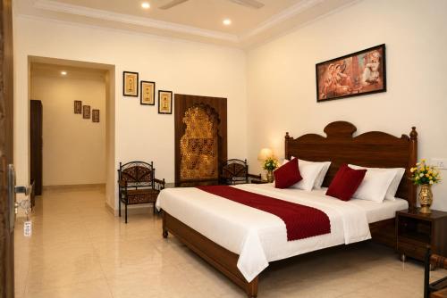 a bedroom with a large bed with red pillows at Central Hotel in Lucknow