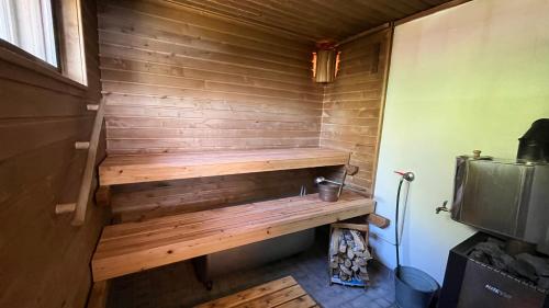 a small sauna with a wooden wall at Karjalan Helmi in Tolosenmäki