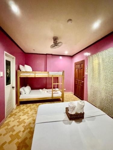 a bedroom with two bunk beds in a room at Tipsy Bay Inn - Malapascua in Daanbantayan