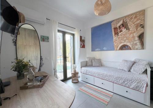 ein Wohnzimmer mit einem Bett und einem Spiegel in der Unterkunft Spitiko Mas in Riglia