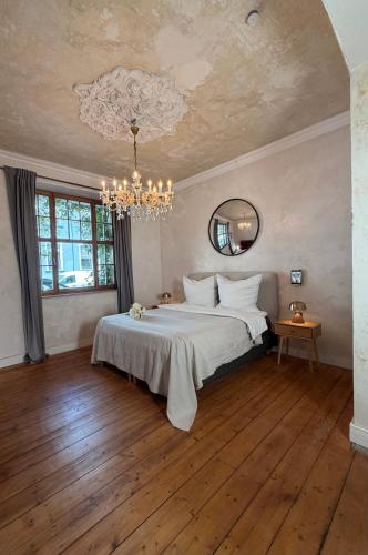 a bedroom with a large bed and a chandelier at Belle Époque in Solingen