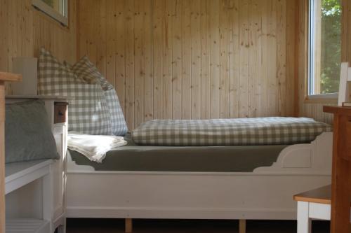 a bed sitting in a room with a window at FreiLAND-Häusle in Weikersheim