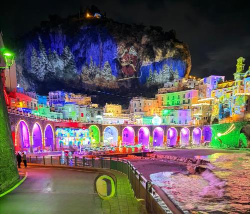 a city lit up at night with colorful lights at Amalfi 2 rooms 1fl no terrace 2fl private terrace sea view in Atrani