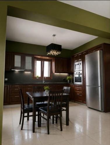 a kitchen with a table and chairs and a refrigerator at Grace, fifteen minutes drive away from the beach in Kolymvari