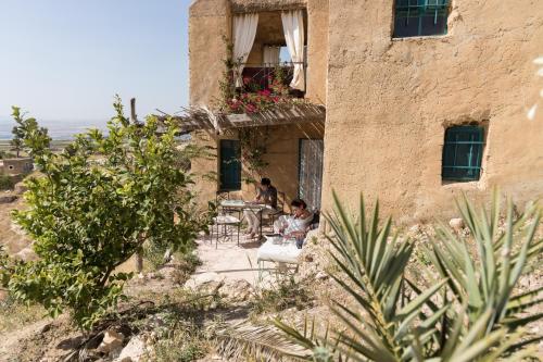 a group of people sitting at tables outside of a building at Beit Al Fannan in Ţabaqat Faḩl