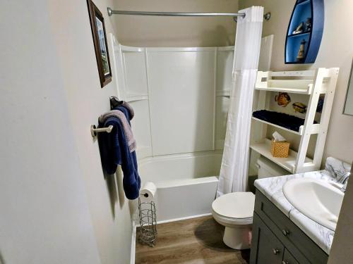 a bathroom with a tub and a toilet and a sink at Beachfront Condo 103 in North Topsail Beach