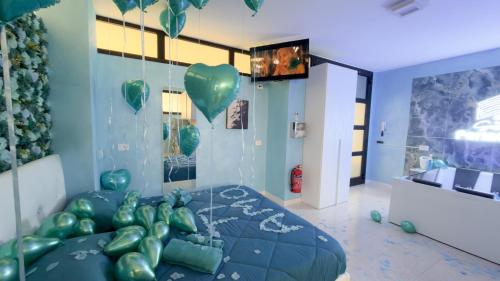 a room with a bed with green balloons in it at Suite Perlacasa in Vigevano