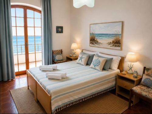 a bedroom with a large bed with a view of the ocean at Brezza Marina & L'oasi Blu in Castelsardo