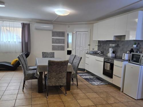 a kitchen with a table and chairs in a room at Holiday Apartman in Kecskemét