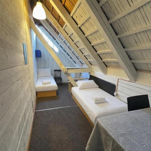 a room with two beds and a table at Ambra Apartaments Palanga in Palanga