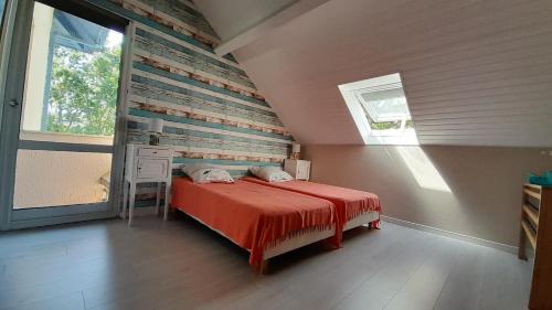 a bedroom with a bed with a wooden wall at T2 en duplex spacieux et central in Andernos-les-Bains