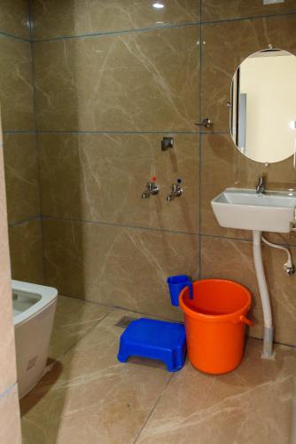 a bathroom with a sink and a toilet and a mirror at Shridevi Residency in Honāvar