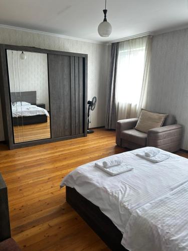 a bedroom with a bed and a couch and a mirror at Home in Udabno in Udabno