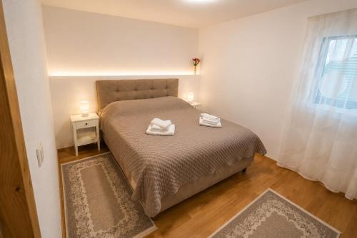 a bedroom with a bed with two towels on it at Sarajevo Apartment in Sarajevo