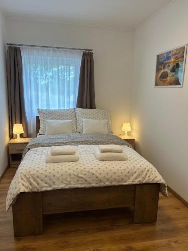 a bedroom with a large bed with two pillows on it at Murvafürt Vendégház in Cserkeszőlő