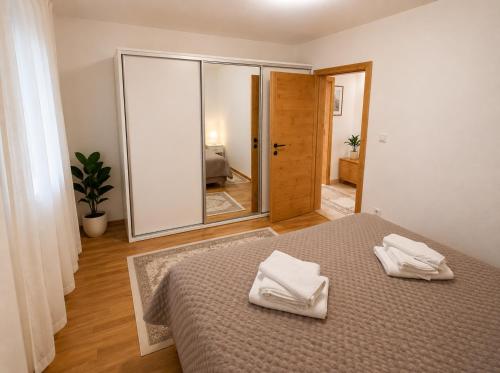 a bedroom with a bed with two white towels on it at Sarajevo Apartment in Sarajevo