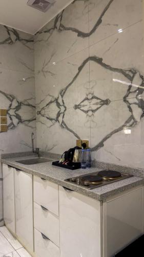 a kitchen with a marble counter top and a sink at سمسمه للشقق المخدومه in Quai