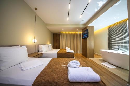 a hotel room with two beds and a bath tub at Hotel Panorama Ksamil in Ksamil