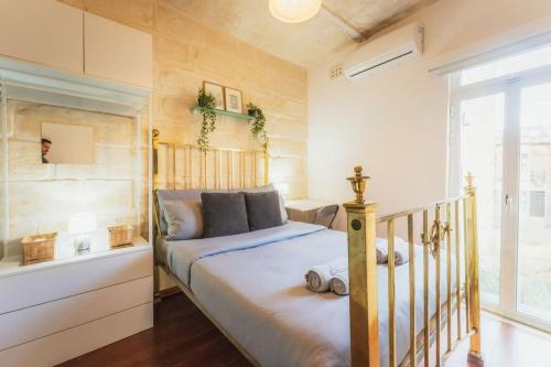 a bedroom with a bed and a window at 3BR Townhouse with Private Rooftop in Bormla in Taʼ Penza