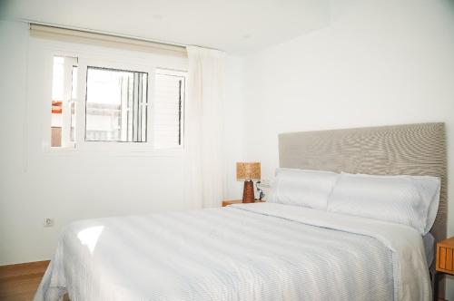 a white bed in a white bedroom with a window at Casa Ines in Playa Honda