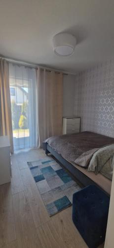 a bedroom with a bed and a large window at Apartament MyMoment in Tupadła