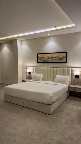 a bedroom with a large white bed in a room at سمسمه للشقق المخدومه in Quai