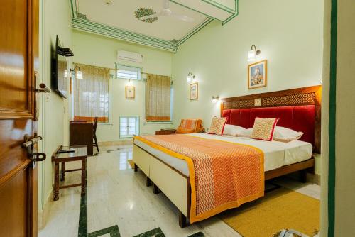 a bedroom with a bed and a chair in a room at Tara Niwas in Jaipur
