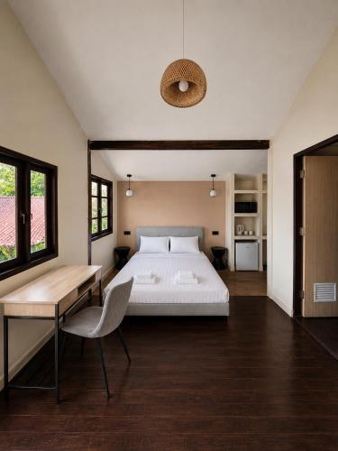 a bedroom with a bed and a table and a desk at Flow Jungle Residency in Haad Yao