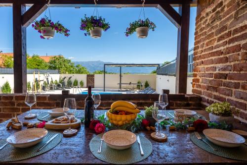 a table with food and wine glasses on it at Villa Dora with heated pool & fitness in Gradina