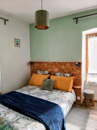 a bedroom with a bed with blue and orange pillows at Gîte la maison de Mika in Saint-Floret