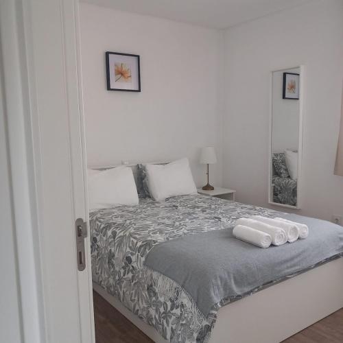 a bedroom with a bed with two towels on it at Casa das Flores in Batalha