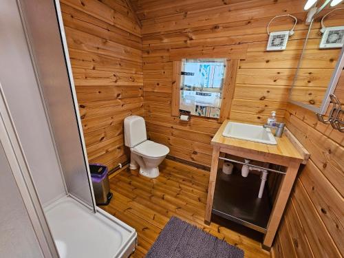a small bathroom with a toilet and a sink at Dalen Gaard camping og hytter in Geiranger