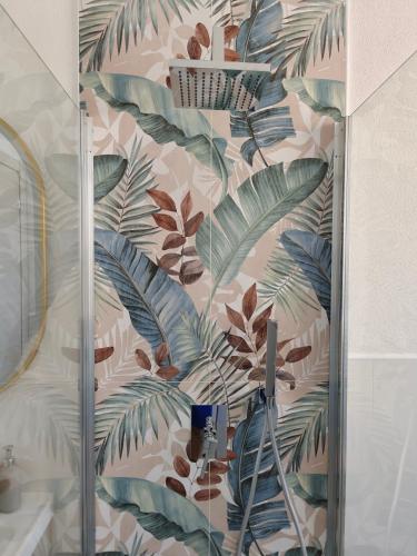 a bathroom with a shower with a mural of leaves at Sole Relax Pula in Pula