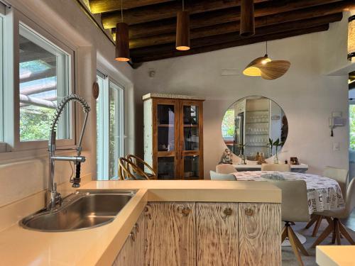 a kitchen with a sink and a dining room at Stupa Eco Vila in Barra de Ibiraquera